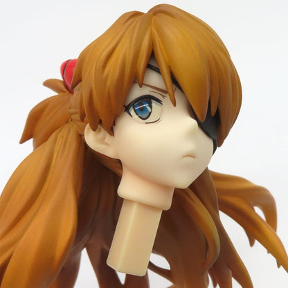 Close-up of an Asuka Langley figure head with orange hair and an eyepatch on a white background