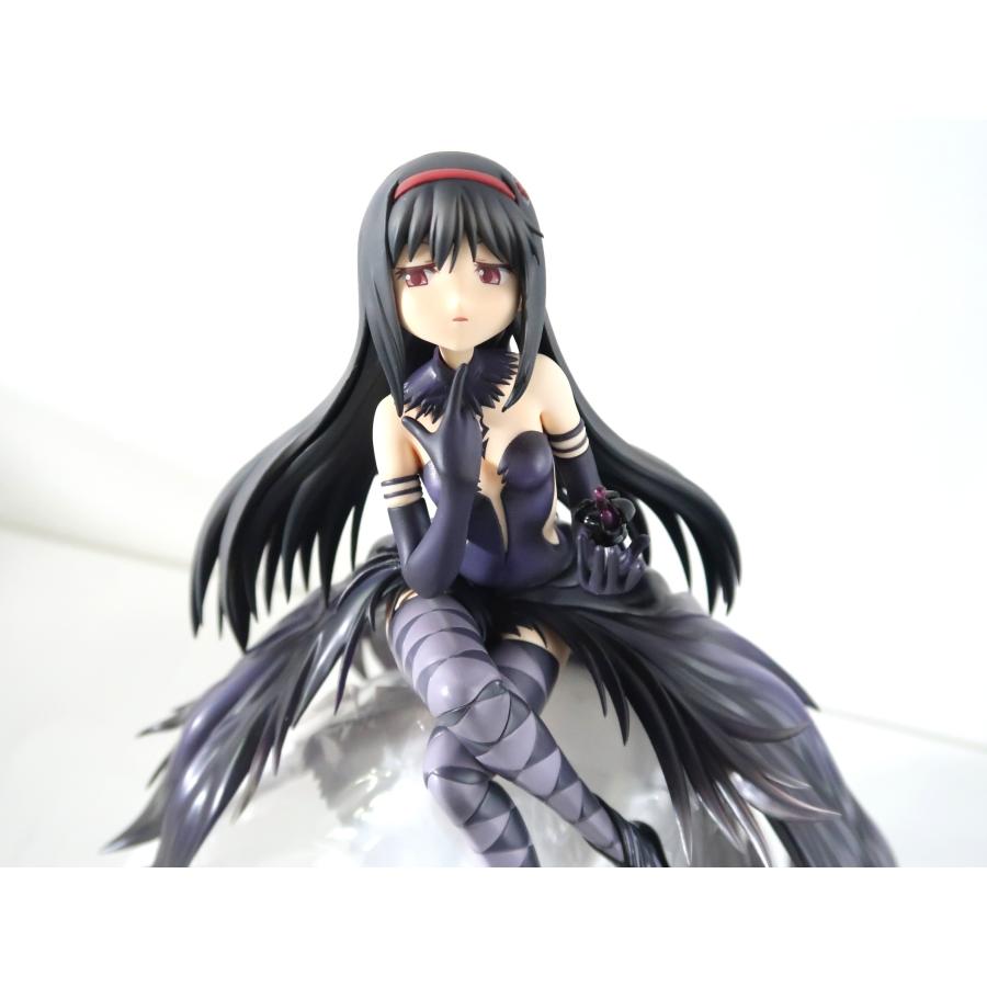 A seated dark-haired anime figure on a white background.