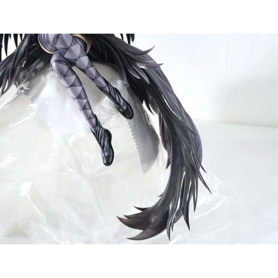 Close-up of a black-haired figure with braided legs on a white background.