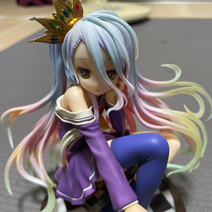 A close-up photo of a Shiro anime figure with long pastel hair and a gold crown.