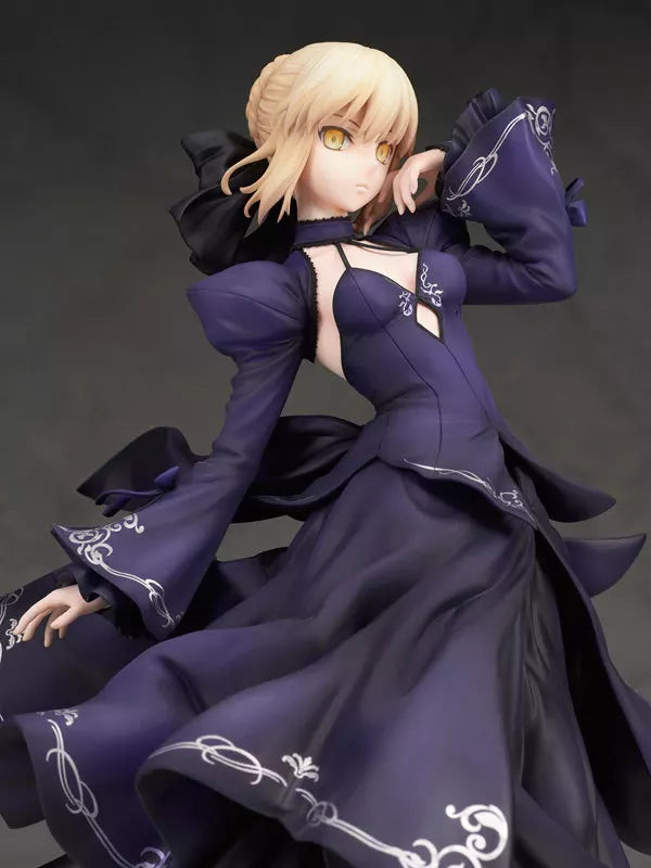 Blonde anime figure in a dark purple dress posing against a dark background.