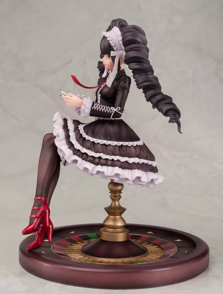 A seated female figure in a black-and-white dress on a round decorated base.