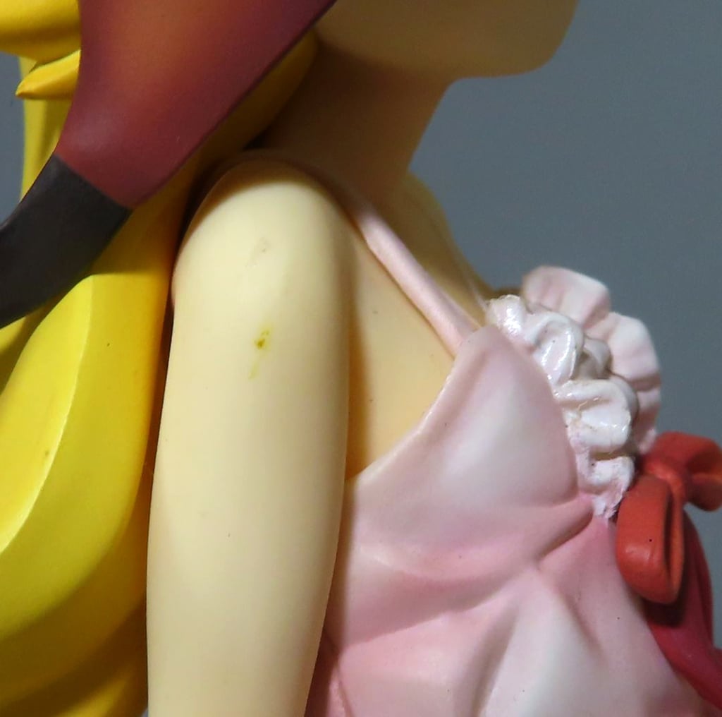 Close-up of a blonde anime figure in a pink dress with a red bow.