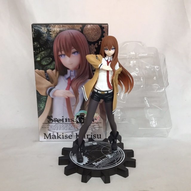 Figure standing in front of its box with a clear plastic blister tray beside it — actual figure with box and accessories together