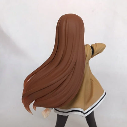 Rear view of a long-haired anime figure in a tan coat on a plain light background.