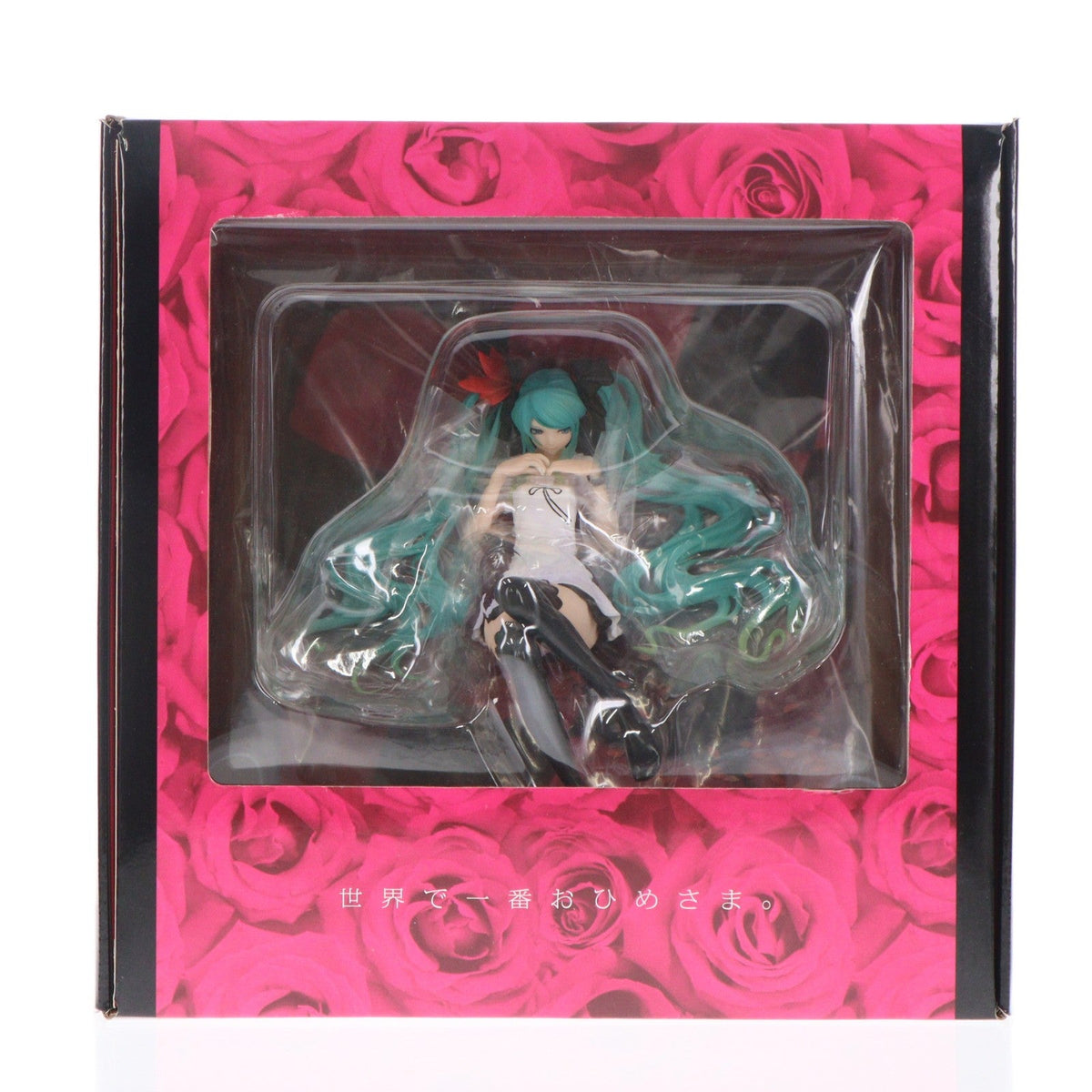 A boxed Hatsune Miku figure visible through a clear window in pink rose-pattern packaging.