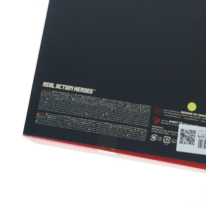 Black figure box lying on a white surface, showing printed product text and a QR code