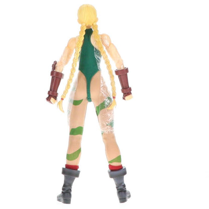 A blonde action figure seen from the back on a white background.