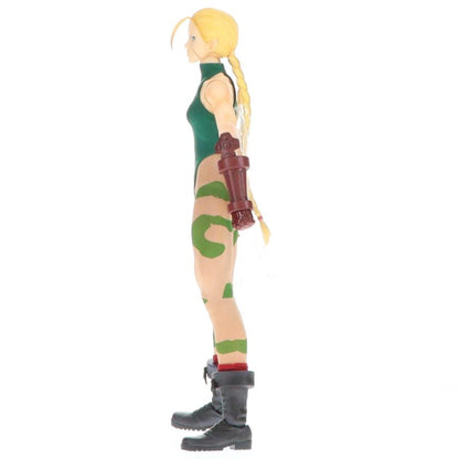 Side view of a blonde action figure standing on a white background.
