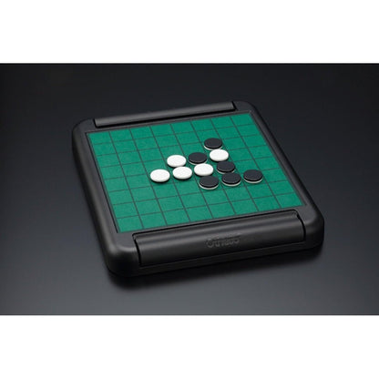 A black folding Othello board with green grid surface and several black and white discs.