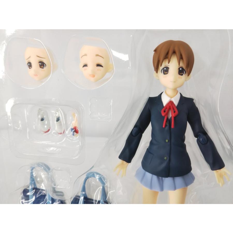Ui Hirasawa figure in a plastic blister with alternate faces, hands and school bags; lower legs cropped.