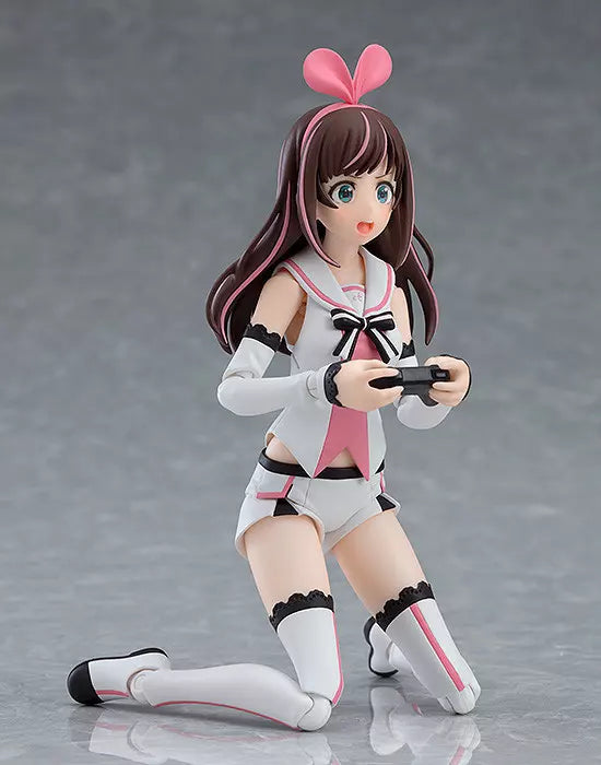 Kneeling anime figure with long brown hair, pink bow headband, and a handheld controller
