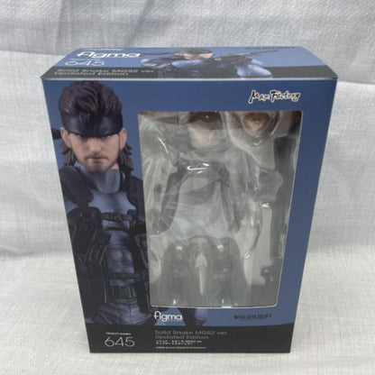A boxed figma Solid Snake figure visible through a front window.