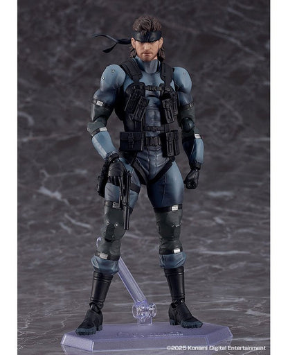 A posed action figure of Solid Snake standing on a clear stand against a dark backdrop.