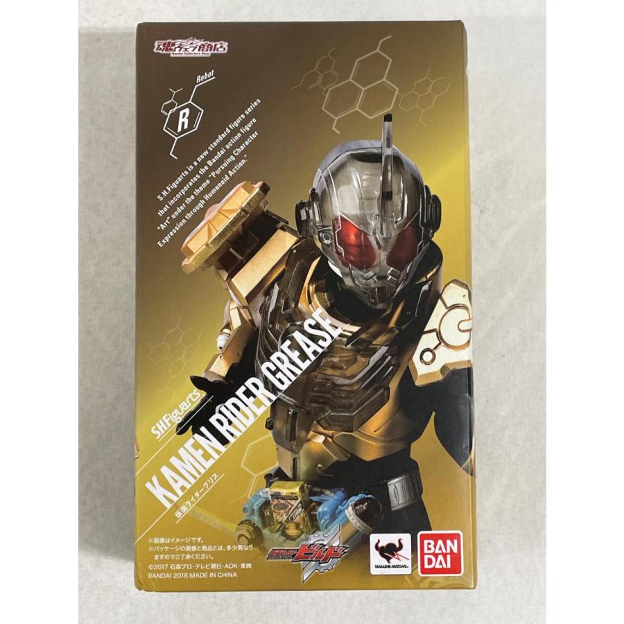 Front of an S.H.Figuarts Kamen Rider Grease box with gold character artwork and Bandai logo.