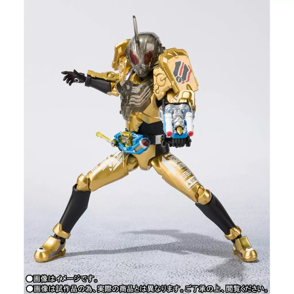 Gold and black Kamen Rider Grease figure posed with legs spread and a wrist-mounted weapon extended.