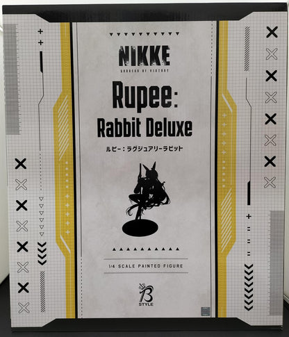 Front of a NIKKE Rupee: Rabbit Deluxe retail box with black and yellow graphics and a figure silhouette.