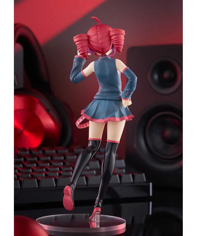 Back view of a red twin-drill figure in a teal skirt and black boots on a clear base, with gaming props behind