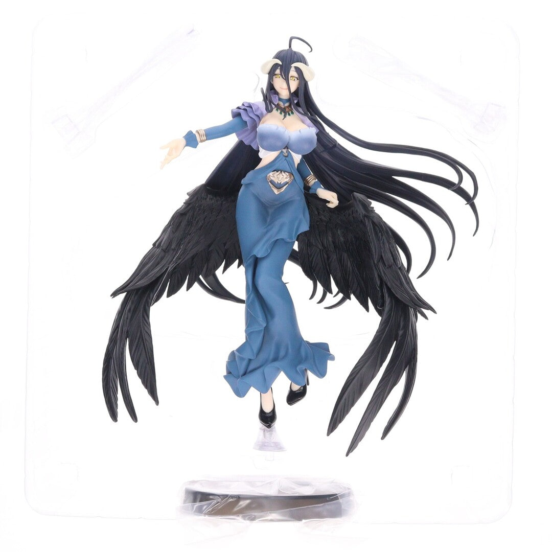 Blue-gowned anime figure with long black hair and black wings, shown in clear plastic packaging on a white bac