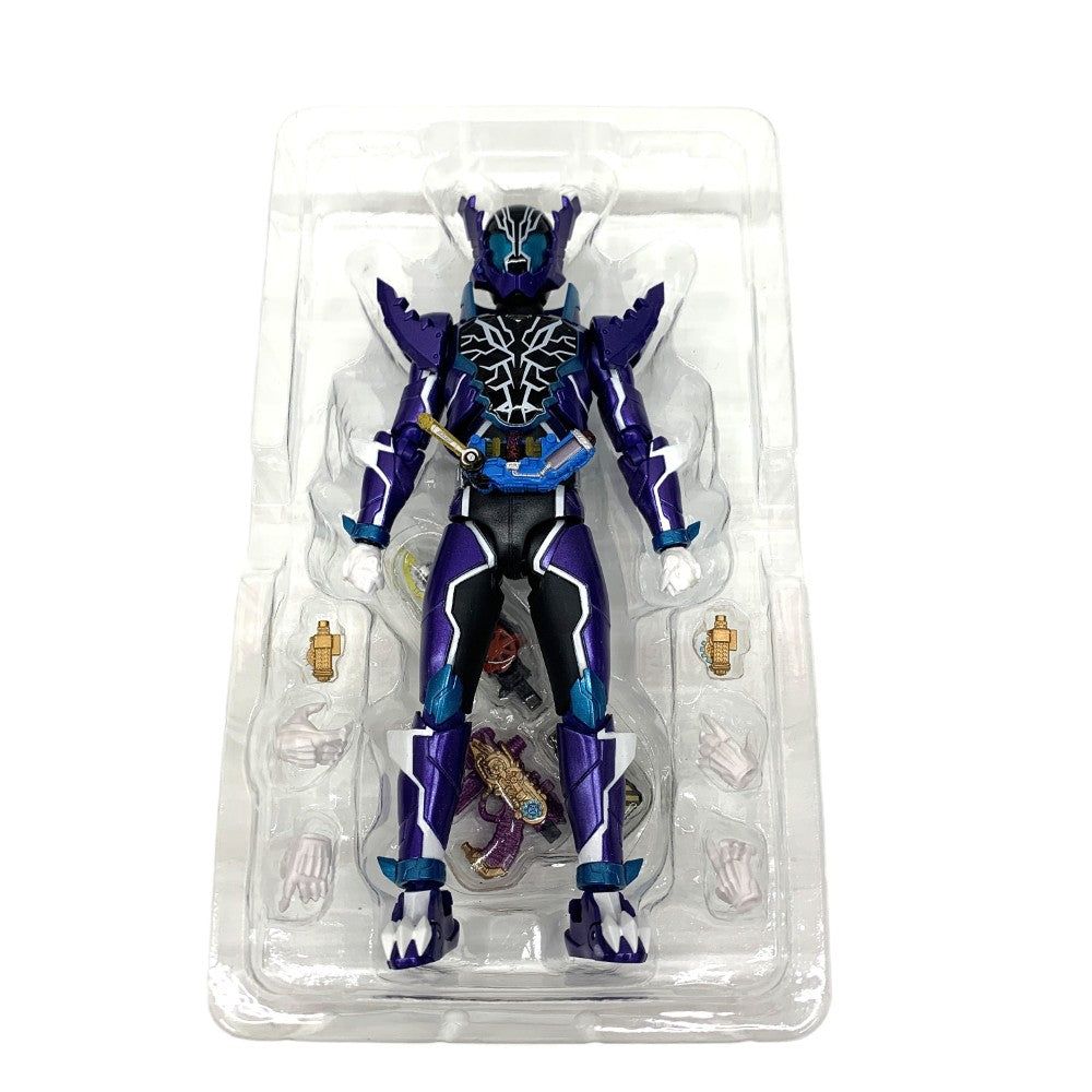 Purple and black Kamen Rider figure with hands and accessories laid out in a clear blister tray on white