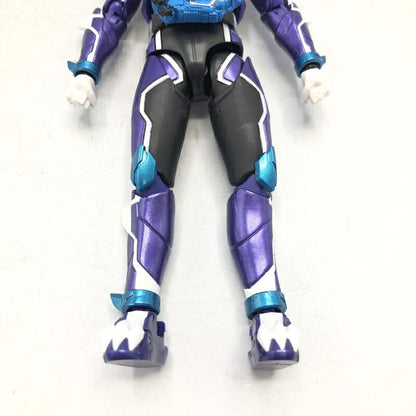 Lower body of a purple, black and teal action figure with white clawed feet on a light background