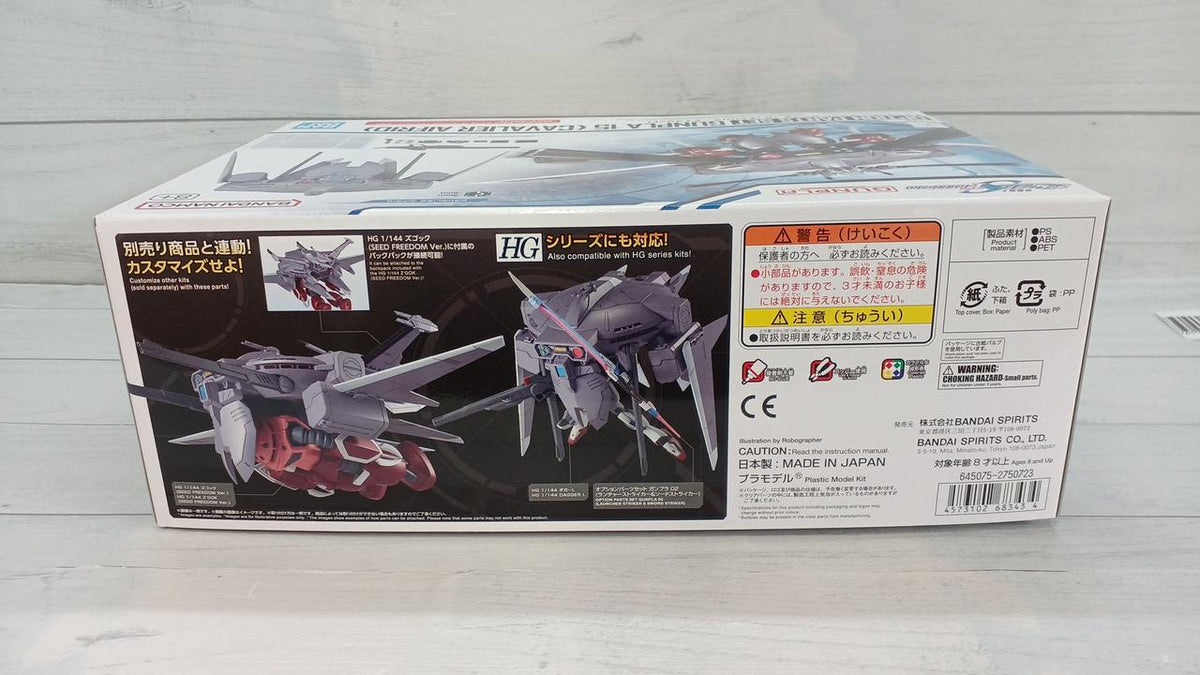 Cavalier Aifrid Gunpla option parts box showing assembly examples, warnings and barcode on a wood surface.