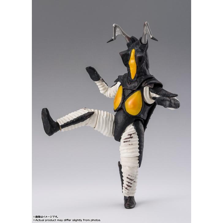 Zetton figure with silver horns and yellow chest panels posed with one leg raised against a gray background.