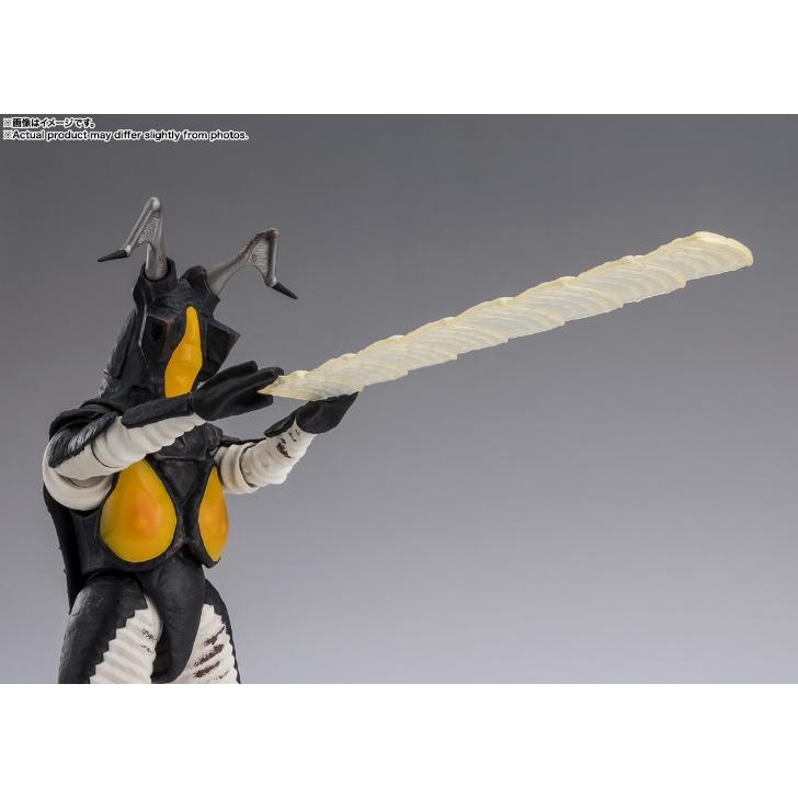 Zetton figure with raised arms and a long translucent beam effect against a gray background.