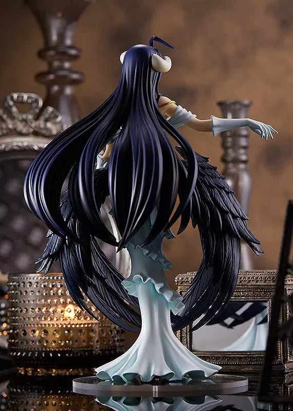 Rear view of Albedo figure with long dark hair, black feathered wings, white dress and an outstretched arm.