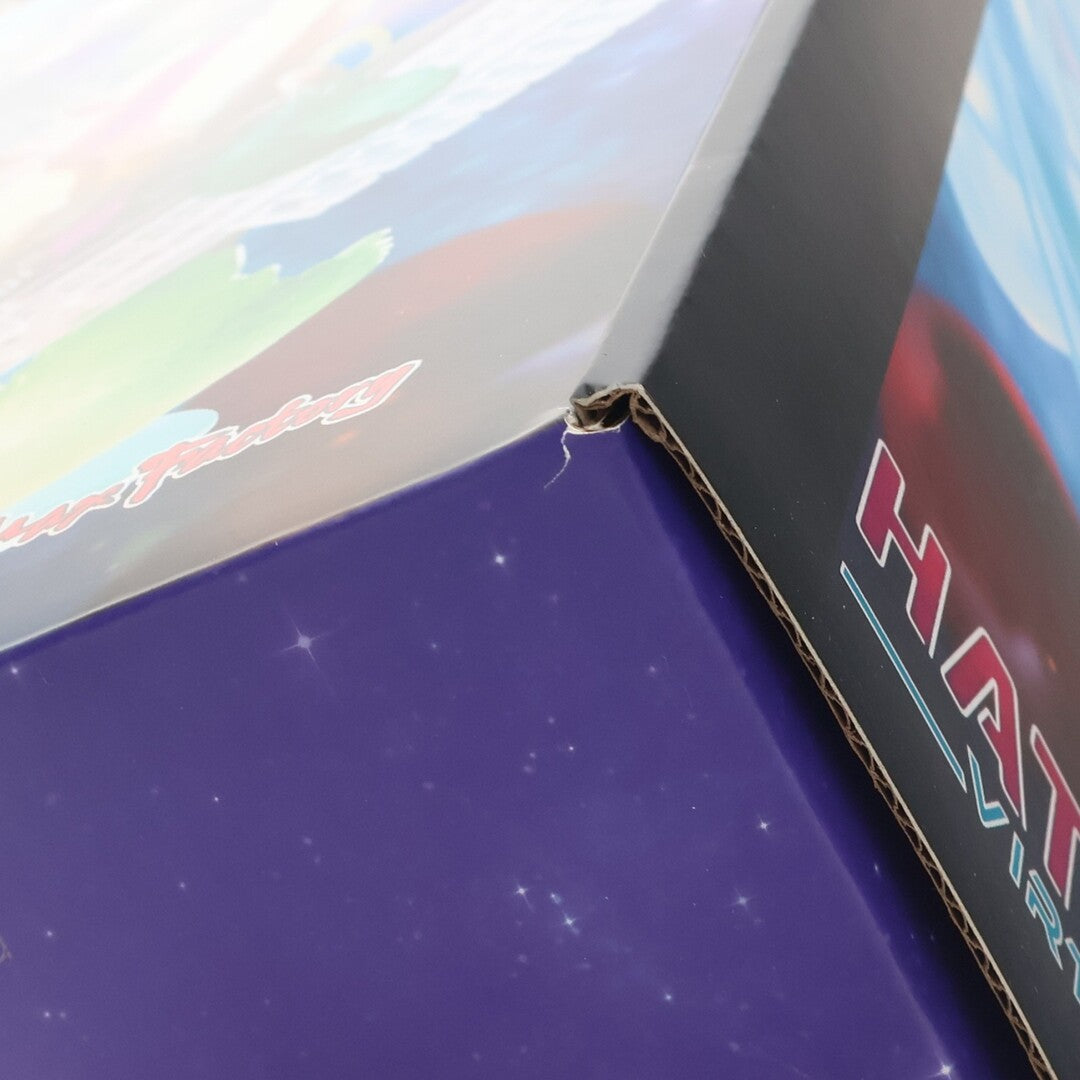 Close-up of a figure box corner with purple and black packaging.