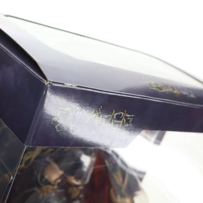 Close-up of a dark figure box with a clear window and gold lettering.
